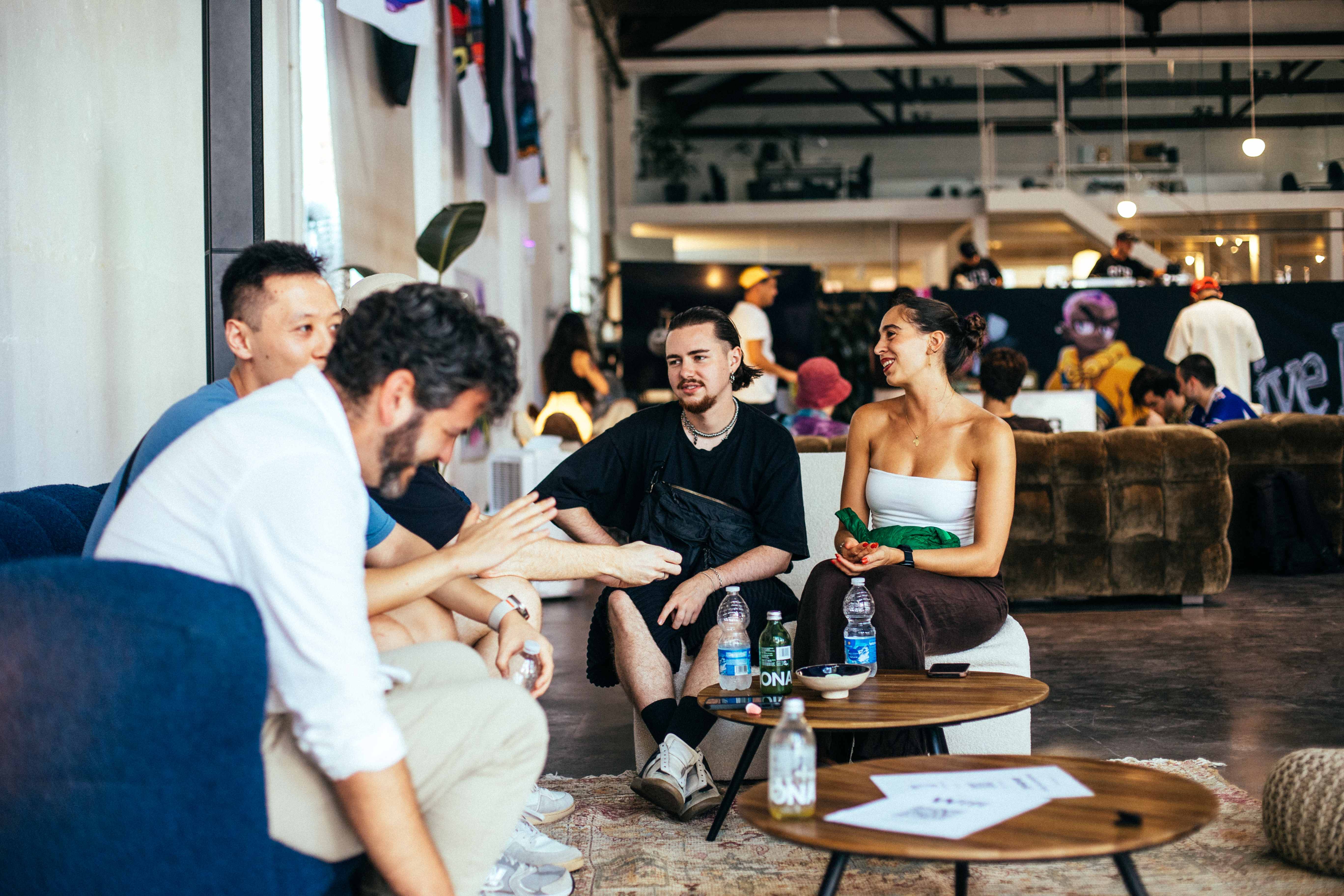 A group of attendees having a conversation in the lounge area during the playtest event.