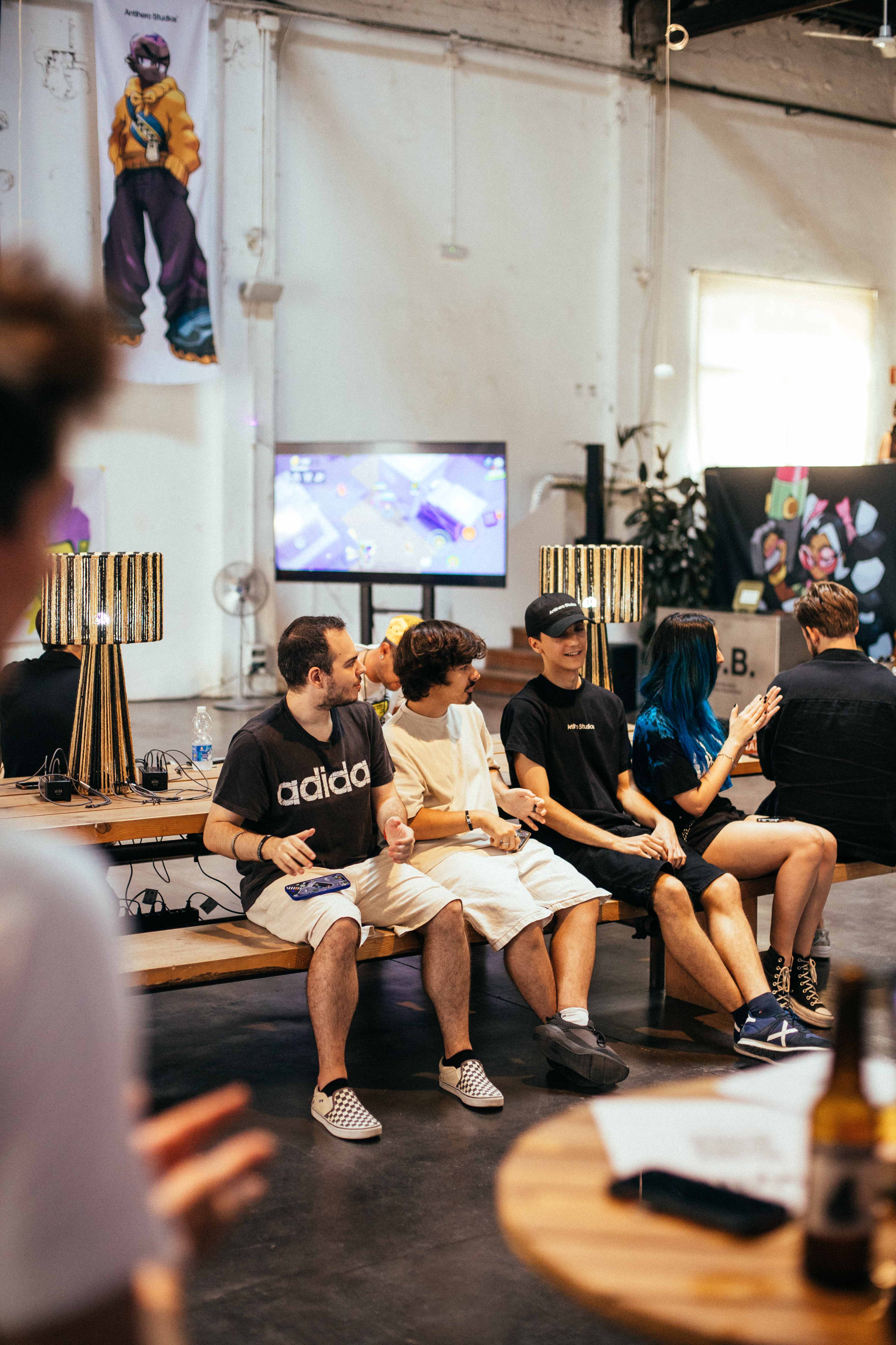 A group of attendees talking and laughing while sitting on a bench.